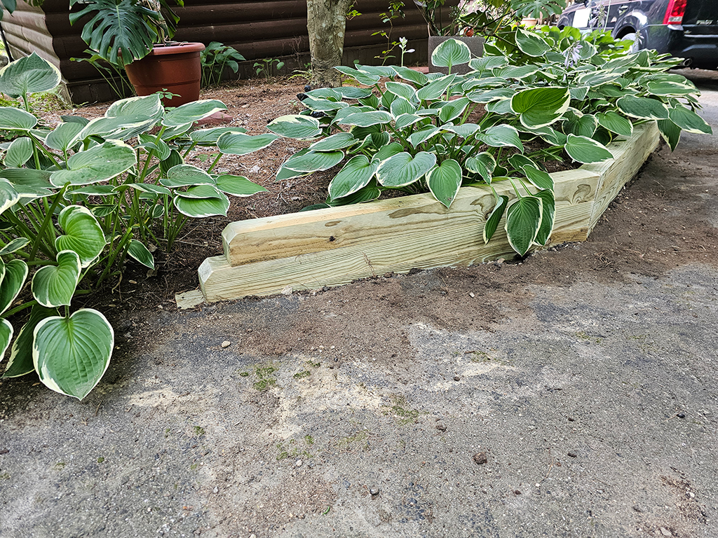 Detail of tapered left end of timber retaining wall with chamfered edges